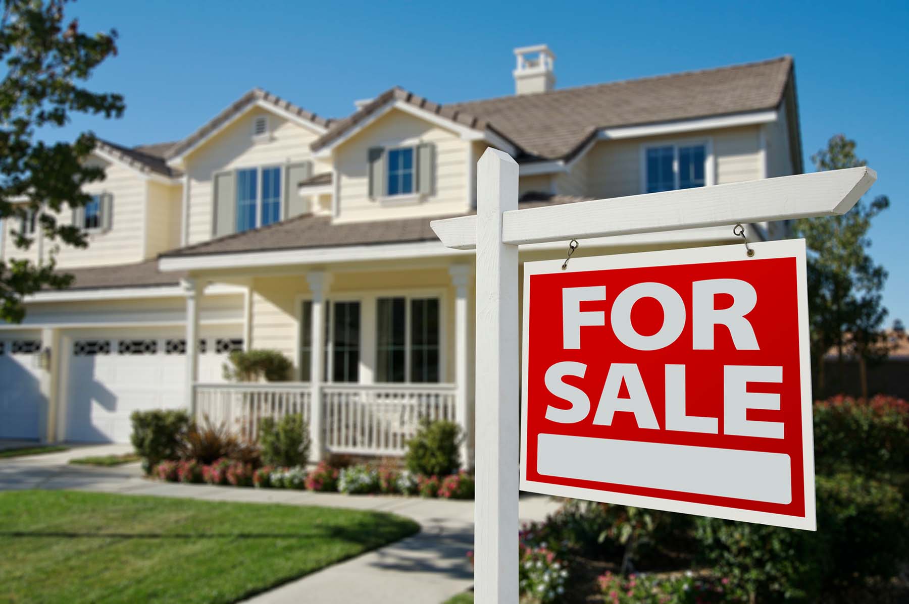 For sale sign in front of house